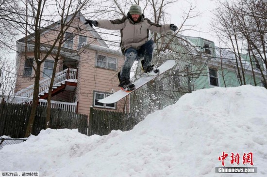 美国波士顿遭暴雪袭击 市民街道玩单板滑雪