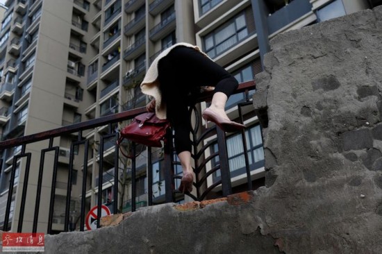 杭州一小区居民每天翻墙出入 早高峰需排队