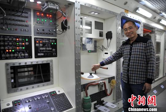 图为许伟龙介绍"天宫一号"模型内部设施. 翟羽佳 摄