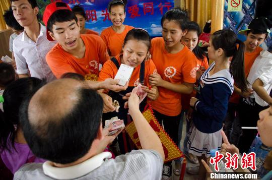 图为北海特殊教育学校的聋哑学生在义卖中用字条与顾客讨价还价.
