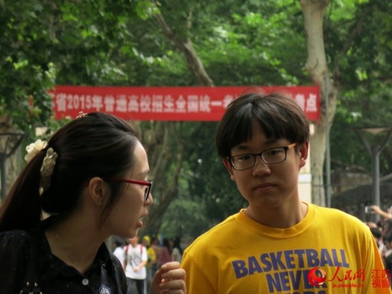金陵中學考點，本網記者（左）在語文考試結束后採訪第一位走出考場大門的考生。