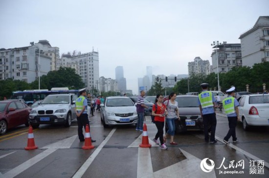 南昌交警在南昌二中紅谷灘校區考點疏導交通，同時為考生和家長服務。