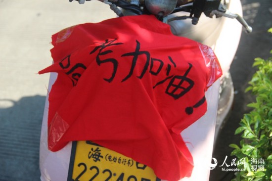 6月8日，海口送考家長電動車上的高考加油橫幅