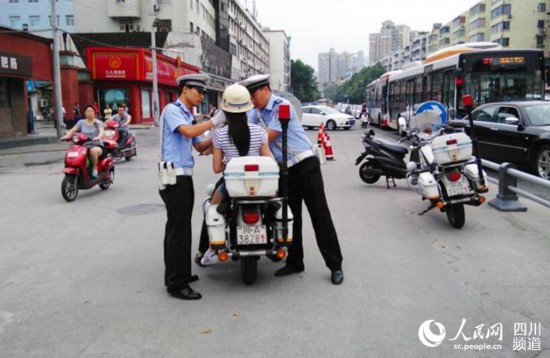 交警在接到考生家長求助后，正要護送考生前往成都市第五十中學應考。（許小燕 攝）