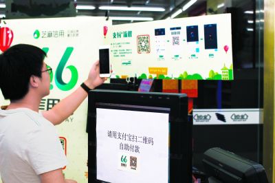 图为消费者在"无人超市"尝试手机扫码支付.记者 张倩怡