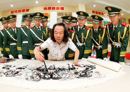 中国美术家协会理事、宁夏回族自治区美术家协会副主席、国家一级美术师郭震乾为国旗护卫队官兵现场创作艺术作品《天骄八骏》 中新社发 王保胜 摄