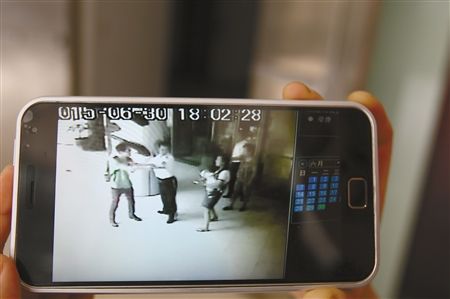 監控畫面中，保安正制止戴眼鏡男子和李女士發生沖突 記者 蔣雨龍翻拍