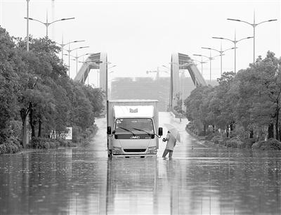 6月27日，江蘇儀征建安路部分路段積水嚴重，車輛通過時熄火。 新華社發