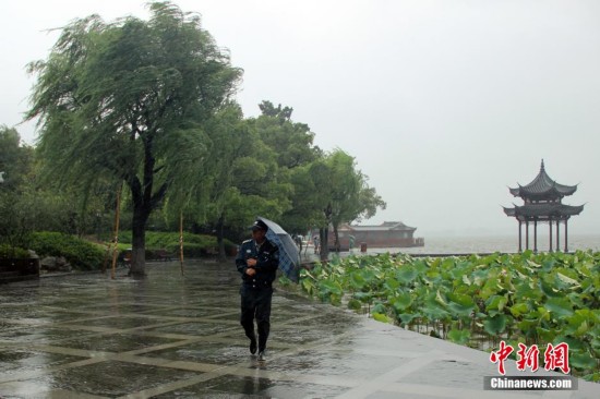 台风灿鸿登陆浙江 游人冒雨赏杭州西湖(图)--