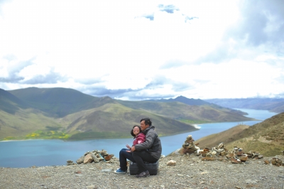 Lai Min and Ding Yizhou cuddle up together to enjoy the scenery at a lake in Tibet on July 9.