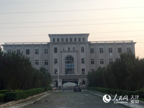 图为13日晨距离事故地点500处拍摄的画面，建筑物受到冲击，门窗受损严重(摄影：人民日报 靳博)