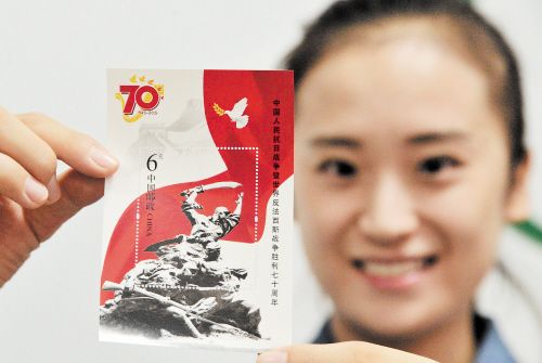9月3日,中国邮政发行《中国人民抗日战争暨世界反法西斯战争胜利七十周年》纪念邮票1套13枚,小型张1枚,全套邮票面值20.80元。图为一名集邮爱好者展示相关小型张。 IC 供图