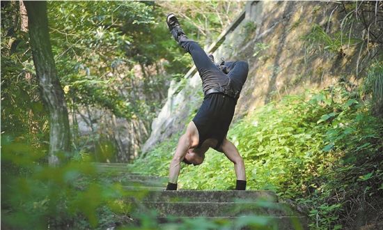 男子先天畸形无法站稳 练倒立爬台阶征服缺陷
