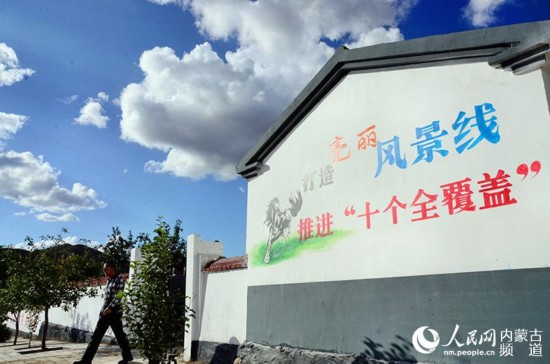 赤峰市巴林左旗半拉溝村粉刷一新的房屋牆上寫著“打造北疆風景線 推進‘十個全覆蓋’”。