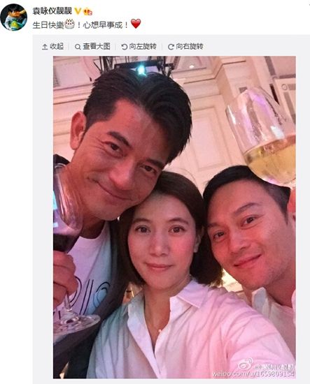 照片中,袁咏仪身穿白色长款衬衣搭配黑色裤子,与张智霖和郭富城合影