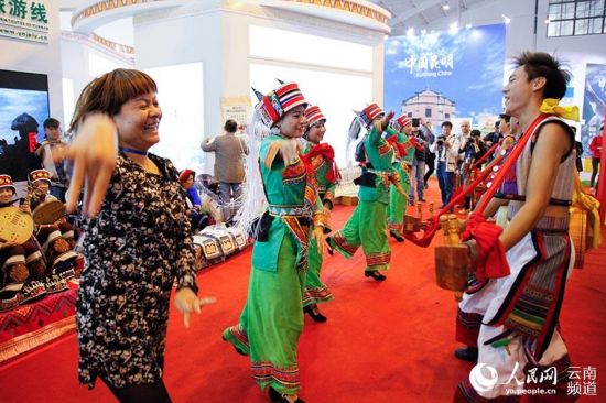 在云南馆,一名客商和石林彝族演员同跳民族歌舞。(人民网 李发兴 摄)