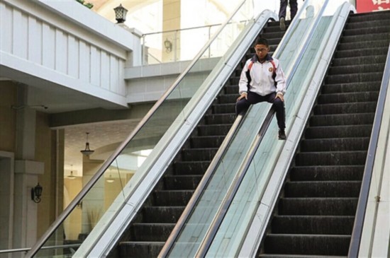 孩子商场电梯扶手上玩起滑梯游戏 危险!