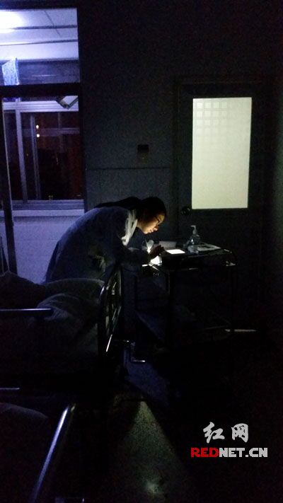 怕吵醒病人，女医生凌晨打手电为病人做检查，一同值班的护士唐玲拍下了这幅照片。