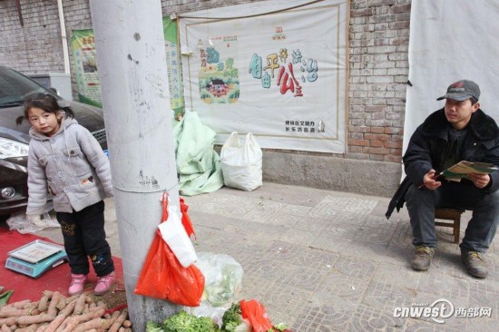 7岁小女孩菜摊旁写作业 帮爸爸卖菜懂事可爱(