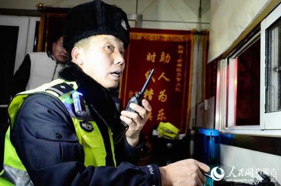 晚高峰執勤時,包青山的對講機不停響起,包青山拿起對講機指導新民警執勤。(陳立庚 攝)