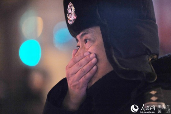 酷寒天氣中執勤交警萬振江手指被凍僵，他不停地哈氣，讓手指暖和一下。楊志勇 攝