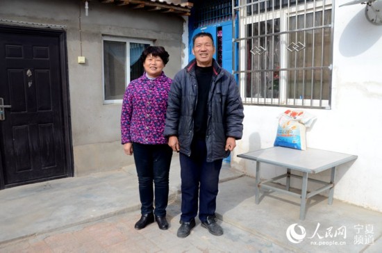 陳廣孝與老伴在自家房前合影。