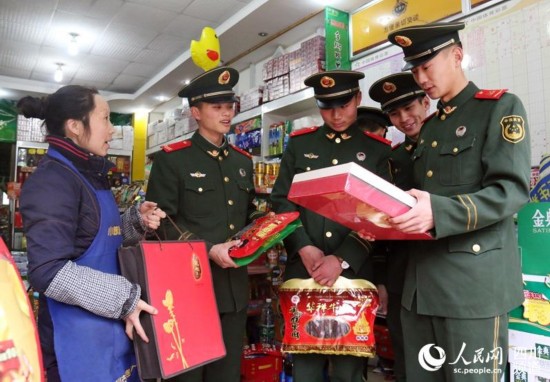 商店老板在給武警官兵們介紹當地特產。（李結義 攝）