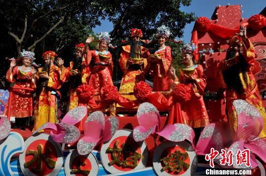 央视春晚花车在广州大巡游 外国帅哥美女扮财