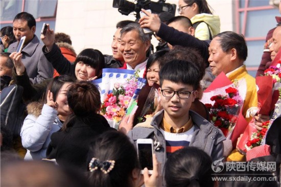 张喜民老师被大家团团围住，笑呵呵的与乡亲们合影。陕西日报记者 陈圣强 通讯员 孟晟博 摄