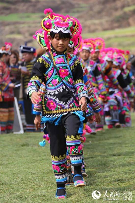 2月22日,来自直苴村附近的彝族小孩在赛装节上展示服装。(人民网-李发兴-摄)