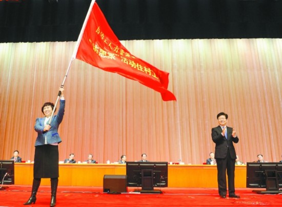 2月24日，在自治區“訪惠聚”總結表彰動員送行大會上，中共中央政治局委員、自治區黨委書記張春賢為第三批“訪惠聚”工作組授旗。  □本報記者盧民一攝