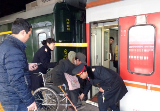 楊靜用輪椅送殘疾人劉國娃到k865次列車 張秋生 攝