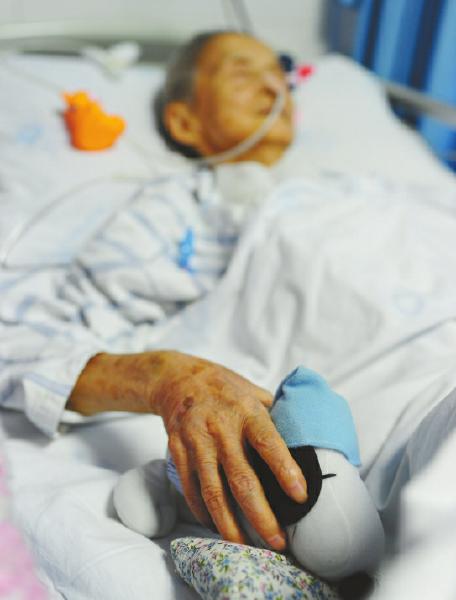 12日,李河清老人正在病床上休息,手里握著家人送给她的玩偶.