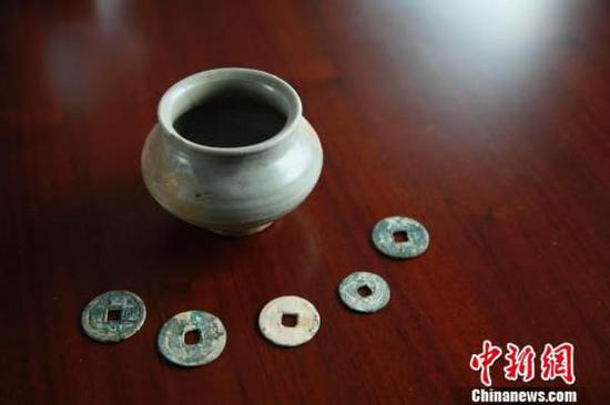 图为安置地发现的宋代青瓷钵和古钱币。郑镇摄 图为安置地发现的宋代青瓷钵和古钱币。郑镇摄