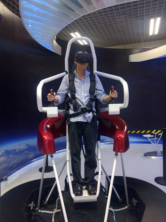 採訪團記者利用虛擬現實裝置，乘坐馬丁飛行包過了一把飛行癮。（王星 攝）