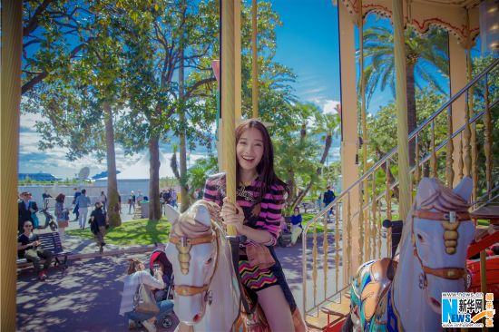 倪妮戛纳街拍清新俏皮 童心未泯玩旋转木马