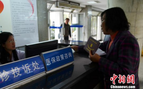 資料圖。一名女子在醫保政策咨詢臺前咨詢。王思哲 攝