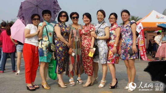 南昌二中的学生家长穿着旗袍出现在考点，她们希望孩子们能在首场考试中旗开得胜。