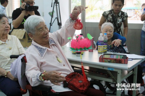 这位阿婆经过激烈竞拍,终于拿到了自己心爱的手工艺品。