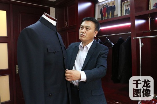 在高黎明手中，一块布料经过裁剪，很快就要变成精美的成衣。千龙网记者 马文娟 摄