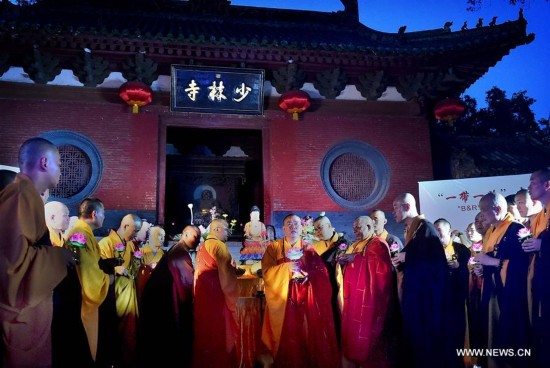 Monks carrying lotus-pattern lamps attend a buddhist ritual at the Shaolin Temple on the Songshan Mountain in Dengfeng City, central China's Henan Province, Aug. 13, 2016.