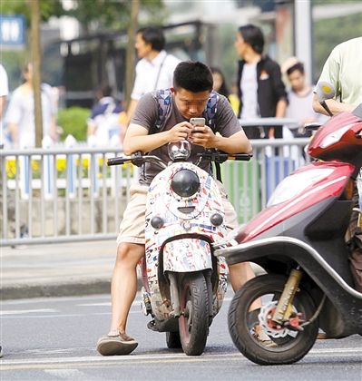 成都交警专项整治电马儿低头族 骑车耍手机将