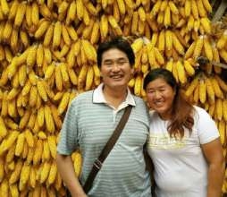 大衣哥朱之文站玉米前搂妻子合影 玉米挂满了