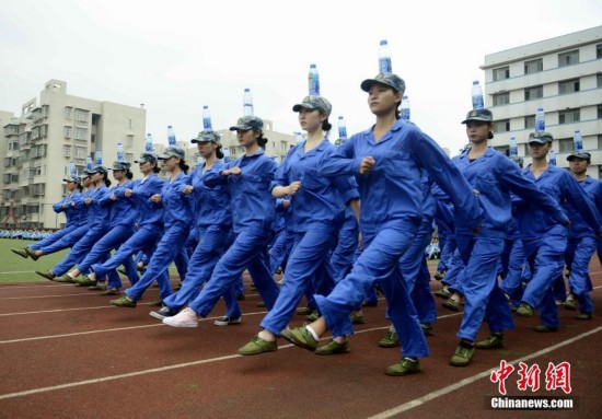女生军训头顶水瓶走正步:训练身体平衡性