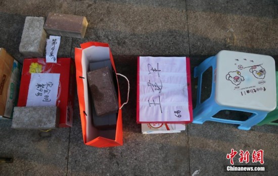 来京人员排队办理北京居住证 用板凳、砖头占