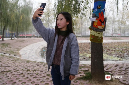 郑州一女大学生为树木手织新毛衣 多彩毛衣惹