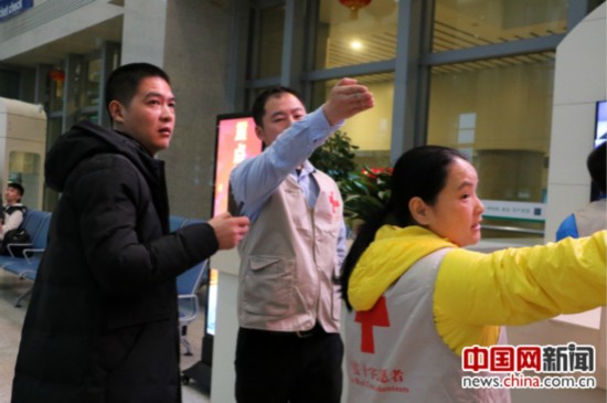 红十字志愿者除了提供急救外，还要解答旅客的各类疑问。志愿者蒋宏杰（中）和同事正在为旅客指路。