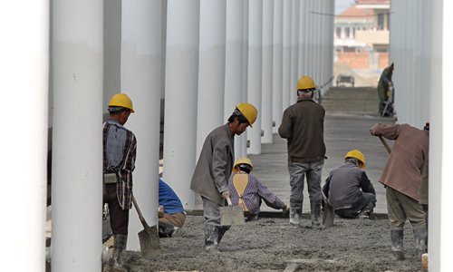 Migrant workers build a train station. Photo:CFP