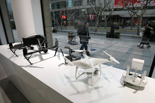 Three drones are on window display at a DJI store in Shanghai. Photo: IC