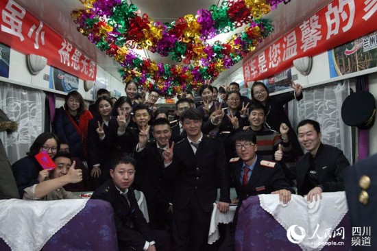 在蘭州開往寧波的K1042次“國際港務區號”品牌列車上，乘務員們精心准備了一台晚會，與旅客一起度過了一個難忘的除夕夜。圖為乘務員與旅客合影留念。（馬勇強 攝）